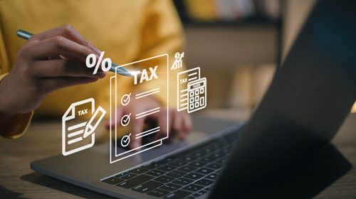 Corporate and individual tax payment concept, woman using comput Corporate and individual tax payment concept, woman using computer filling out corporate and personal income tax return, VAT and property tax of business.